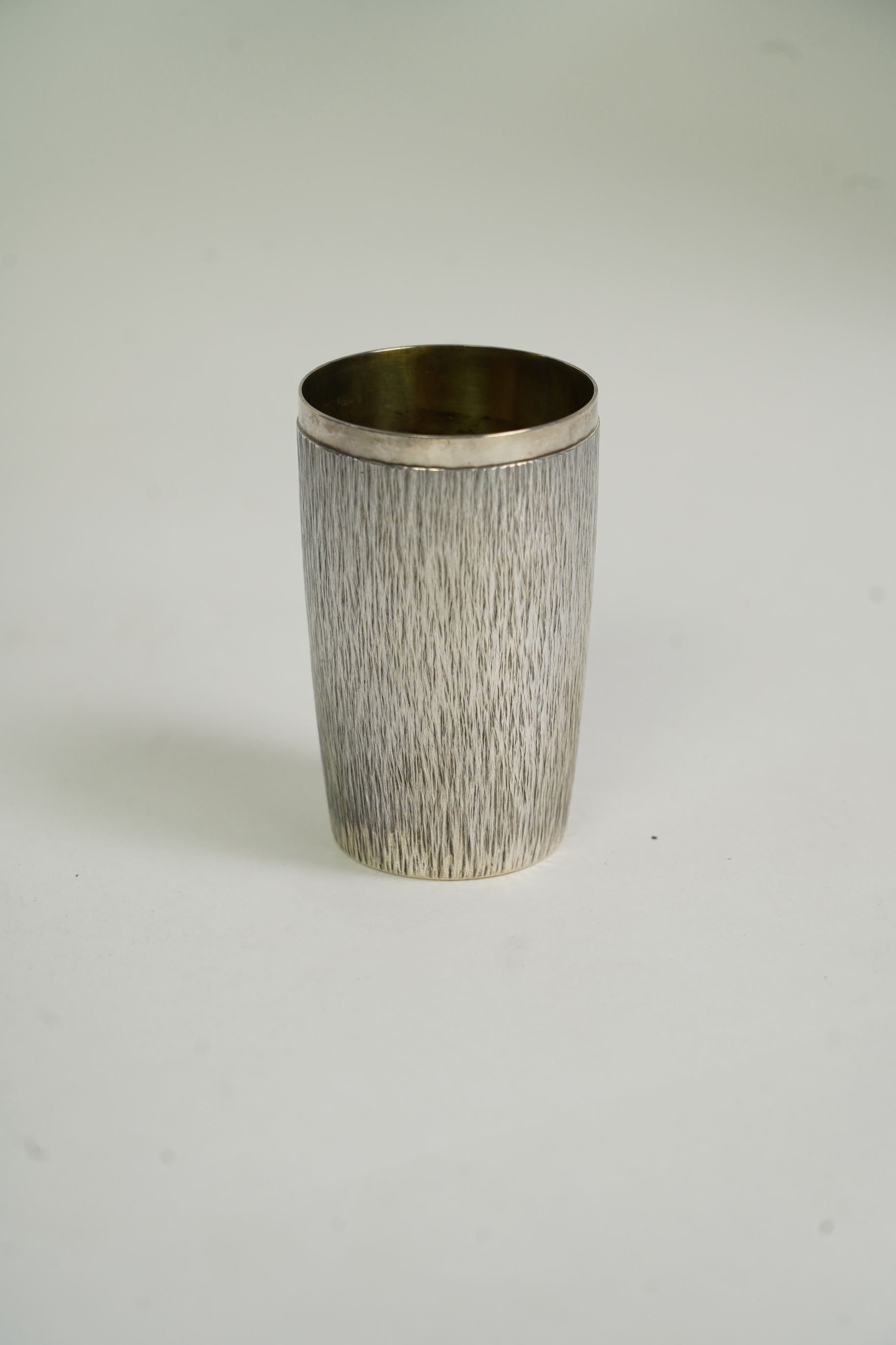 An Elizabeth II bark effect textured silver beaker by Adrian Gerald Benney